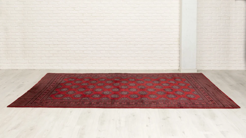 Alfombra pakistaní de lana roja con diseño geométrico y dibujos repetitivos