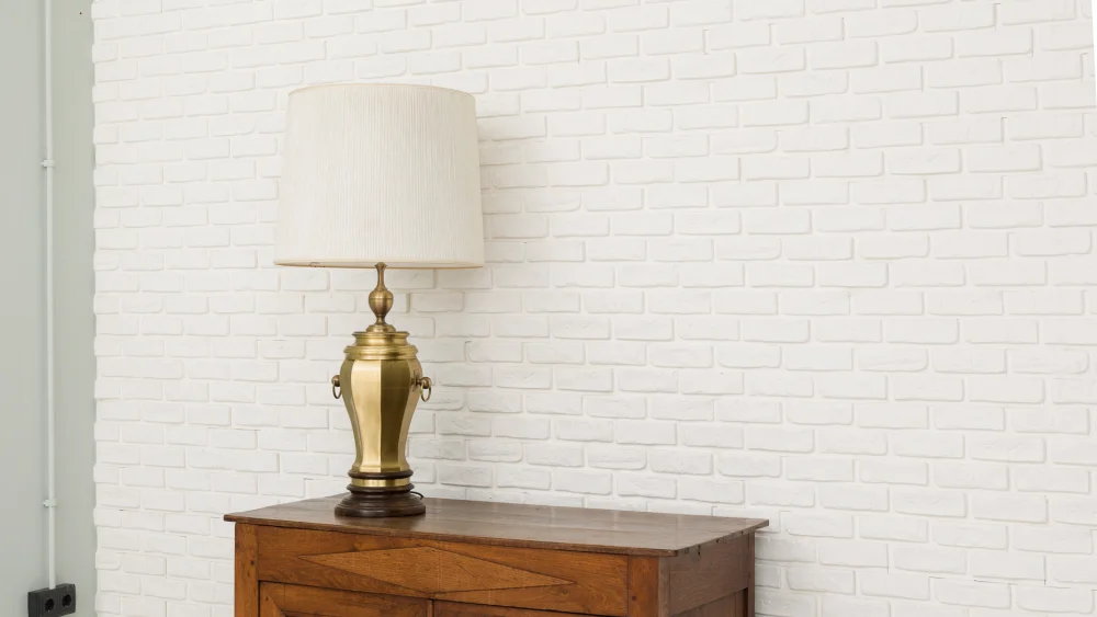 Lámpara de diseño Altisent con base de madera, cuerpo dorado y campana blanca